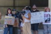 Students hold signs with messages such as Stand against ICE and ICE is the KKK as they stand behind the main female speaker who holds a meglaphone and adorns a keffiyeh